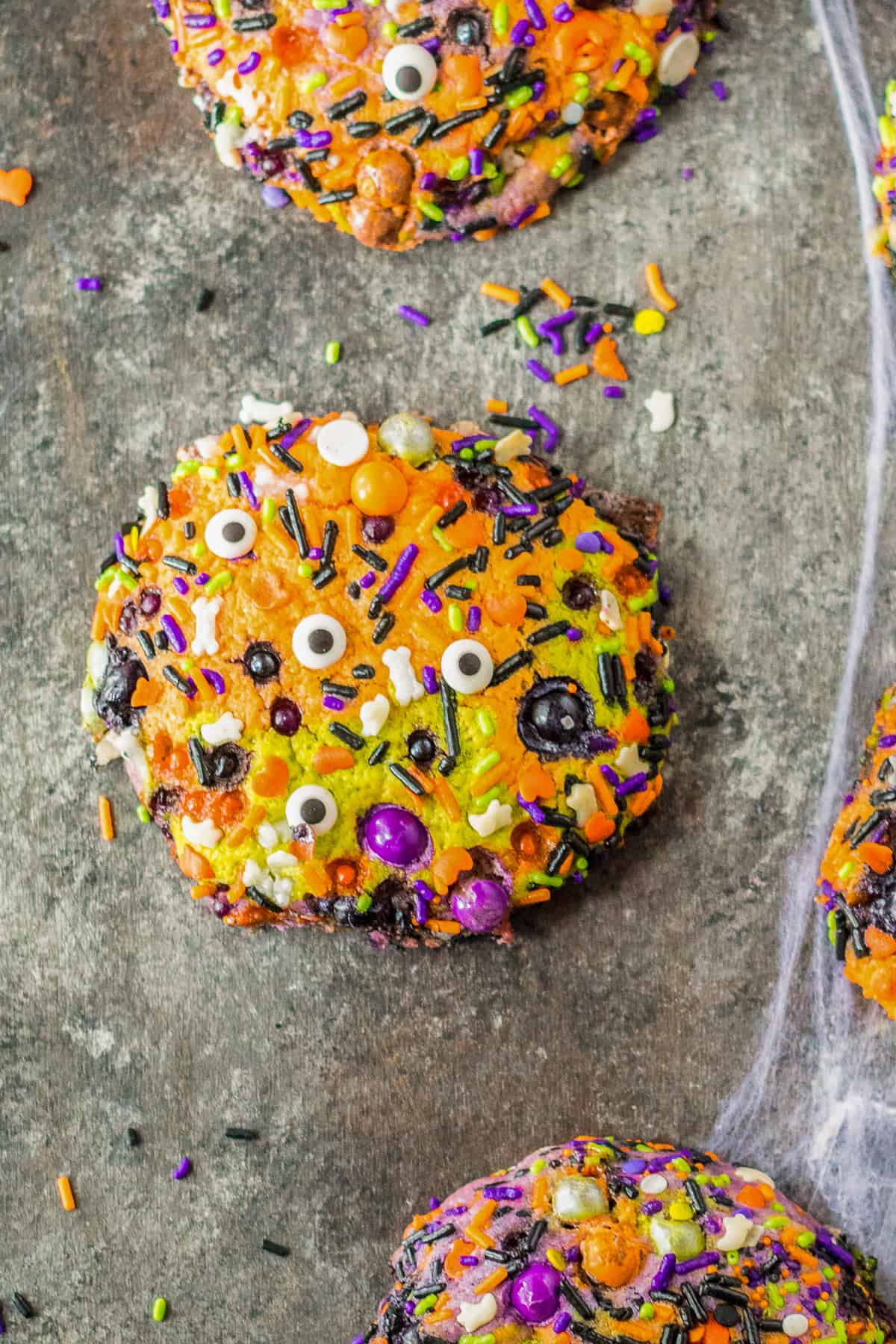 halloween sprinkle cookies with googly eyes on dark background