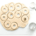 cutting out doughnuts from dough.