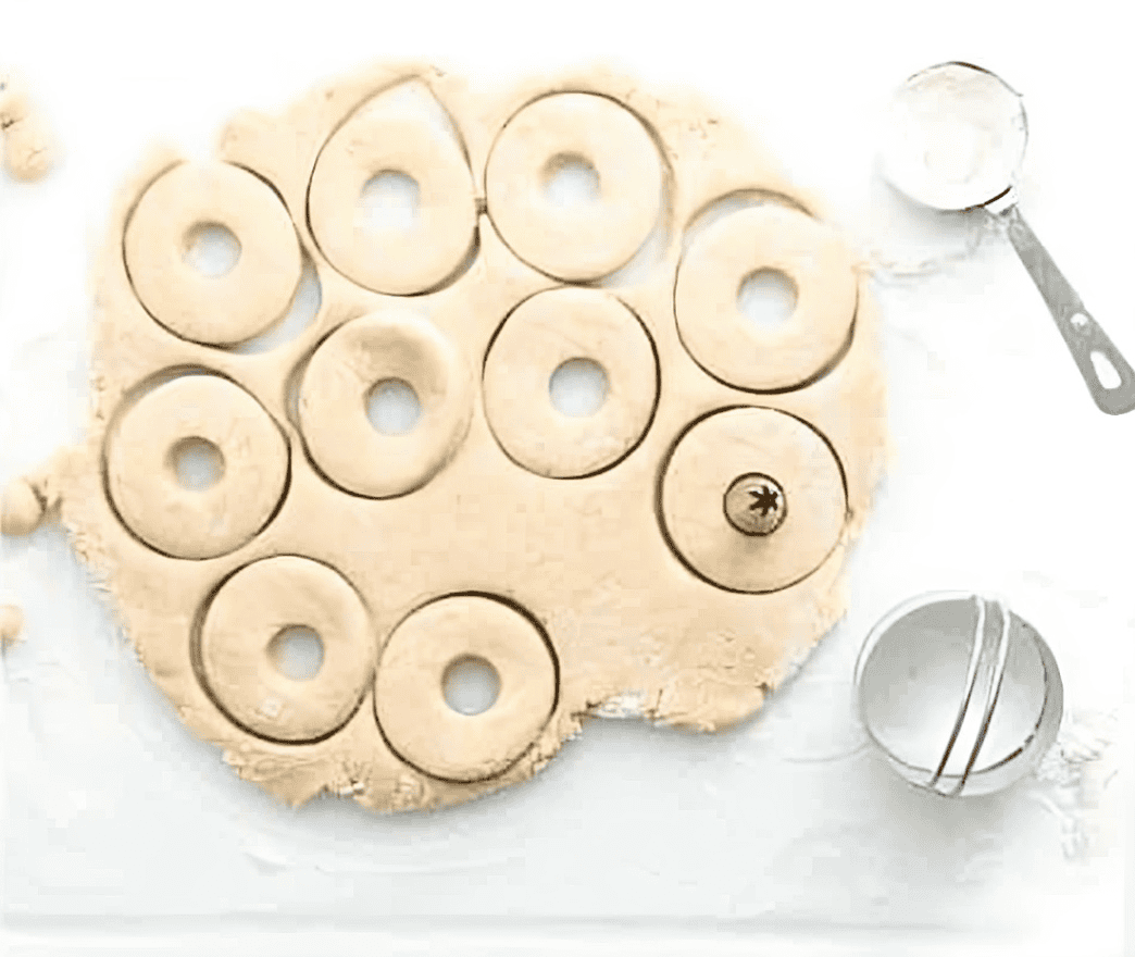 cutting out doughnuts from dough.