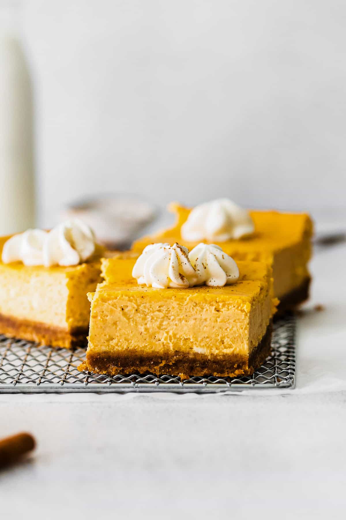 up close pumpkin cheesecake bars with whipped cream