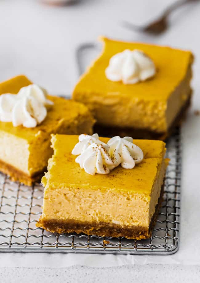up close pumpkin cheesecake bars with whipped cream