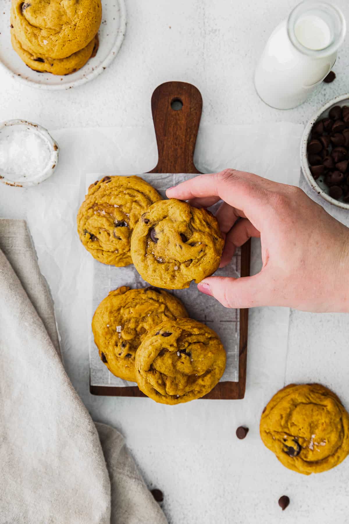 hand lifting up pumpkin chocolate chip cookie