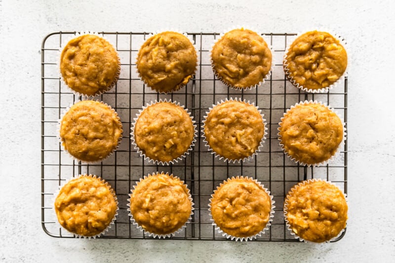 overhead image of 12 apple cupcakes without frosting on a cooling rack