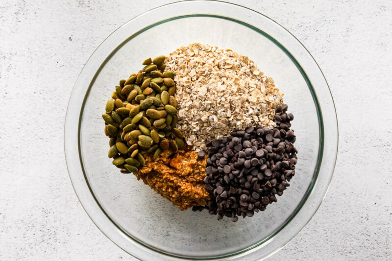 ingredients for pumpkin chocolate chip oat bites in a glass bowl before mixing