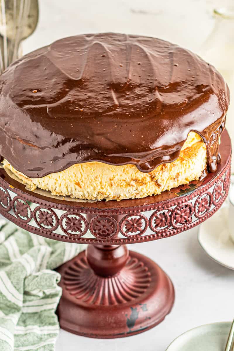 boston cream pie cheesecake on red cake stand