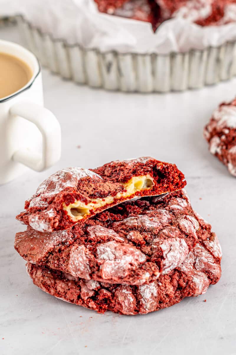 cheesecake stuffed red velvet cookies with one broken in half showing the cheesecake filling