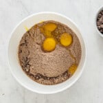 dry chocolate cake mix and eggs in a white mixing bowl