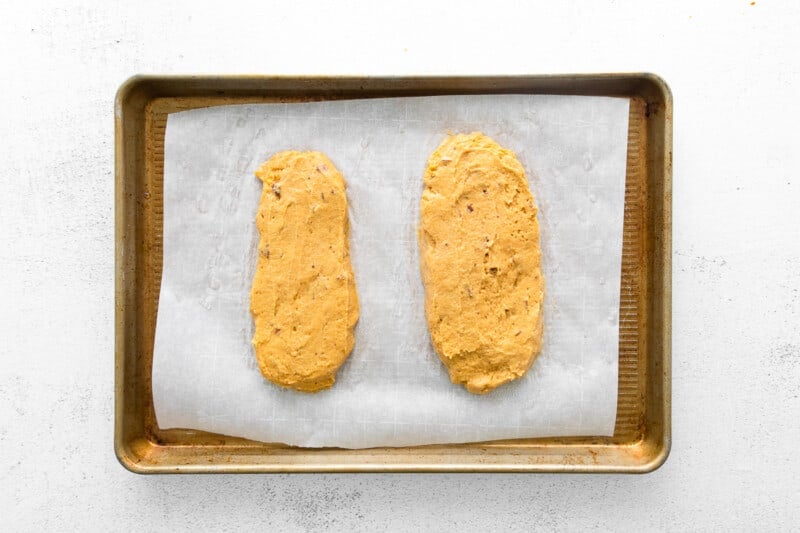 2 loaves of pumpkin pecan biscotti dough on a baking sheet before baking