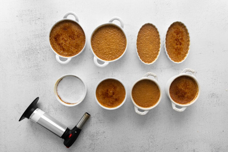 8 ramekins of creme brulee topped with a torched sugar topping