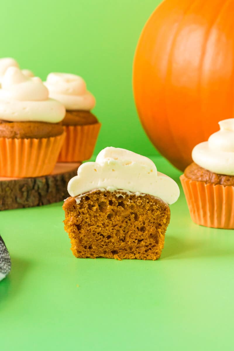 pumpkin cupcake with cream cheese frosting cut in half showing the texture