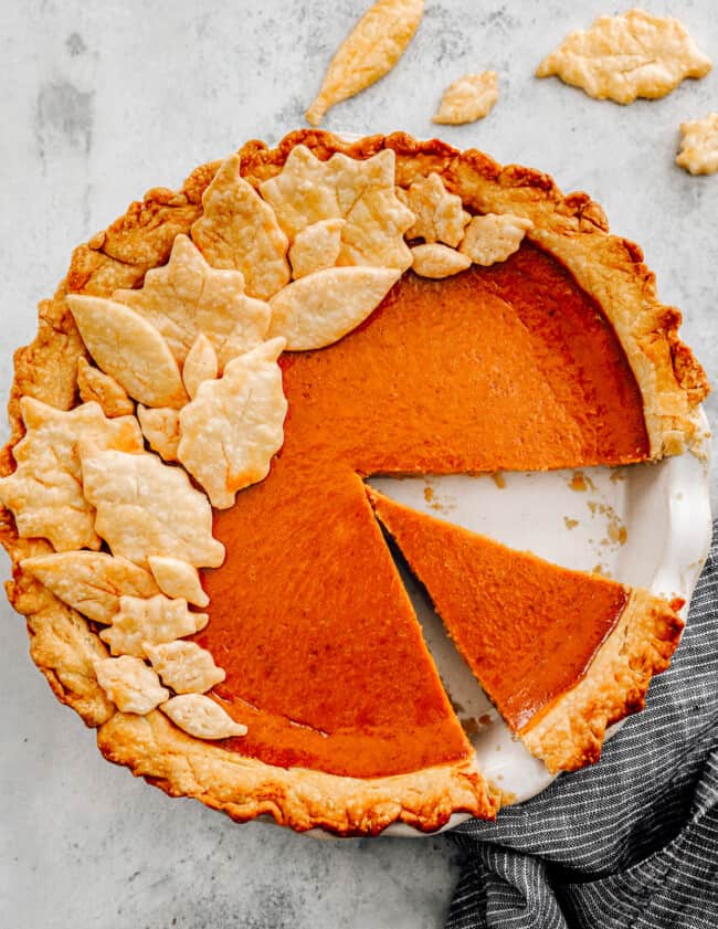 overhead image of pumpkin pie with a slice removed