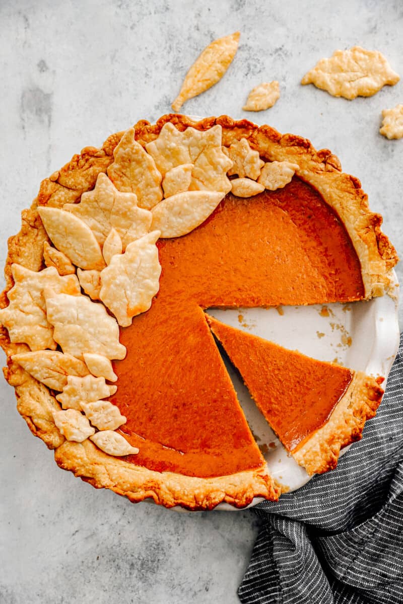 overhead image of pumpkin pie with a slice removed