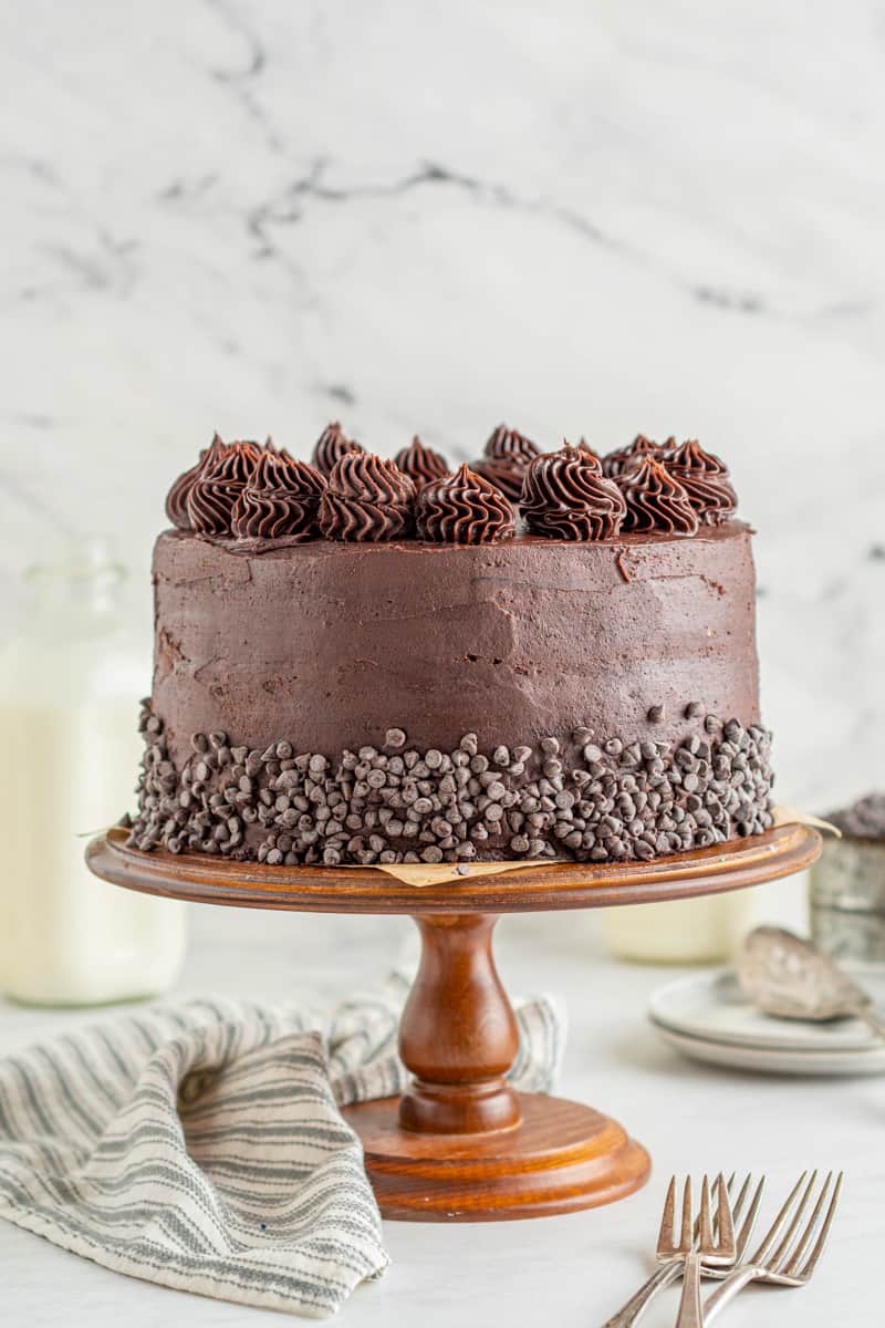 chocolate cookie dough layer cake on a wood cake stand