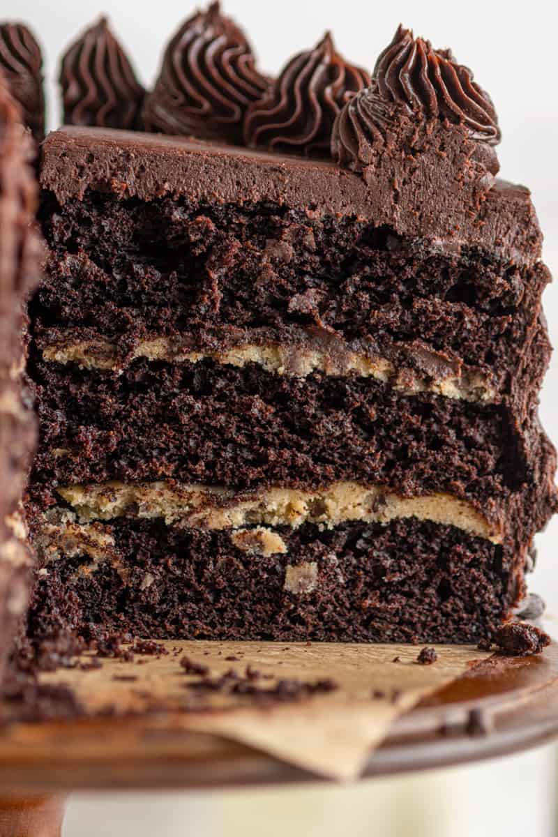 chocolate cookie dough layer cake with a slice removed showing the inside layers