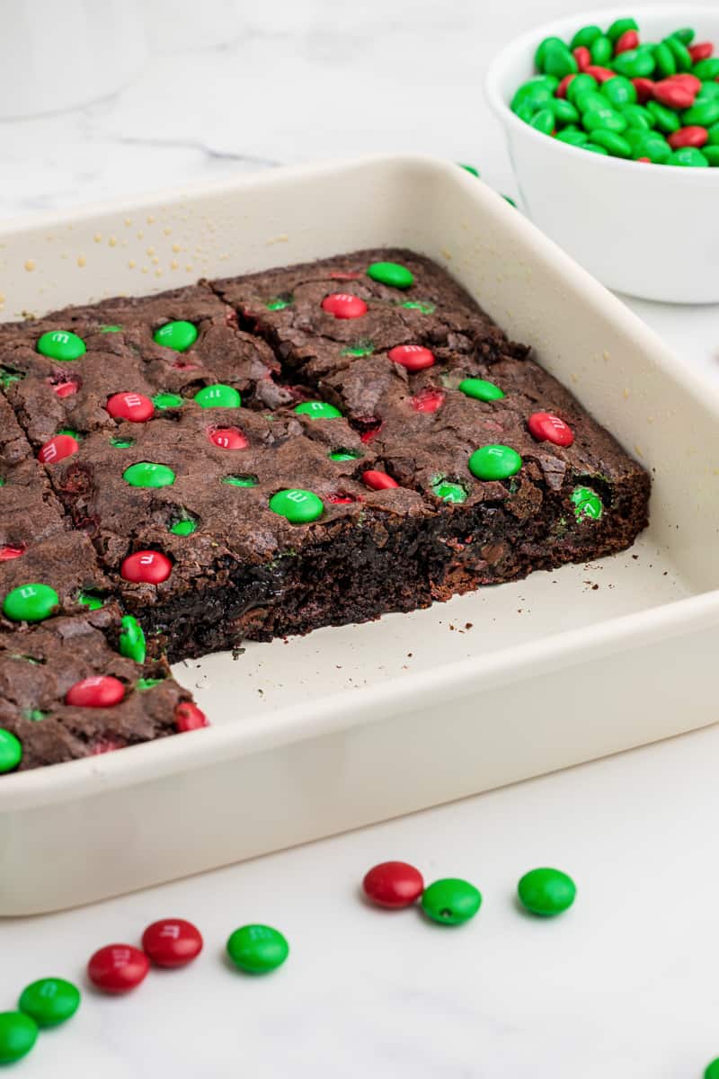 brownies with christmas M&Ms in a white baking dish