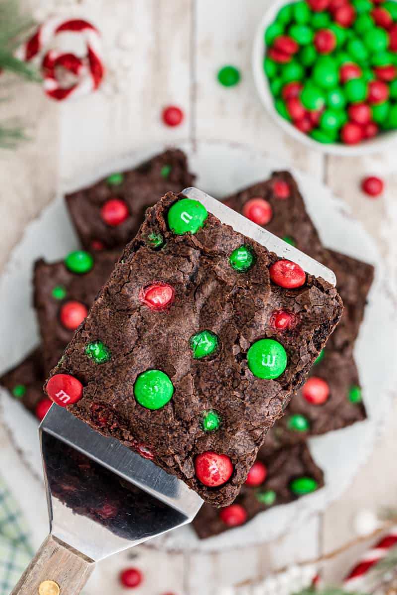 overhead image of a brownie with christmas M&Ms on a spatula
