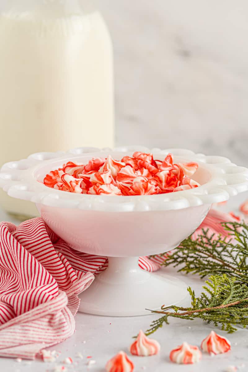 red and white cream cheese mints in a white serving bowl