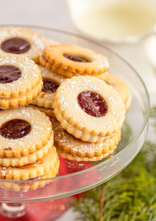 linzer cookies on a glass cake stand
