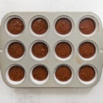 chocolate pumpkin cupcake batter in a lined muffin tin.