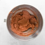 overhead view of chocolate pumpkin cupcake frosting in a stainless mixing bowl.