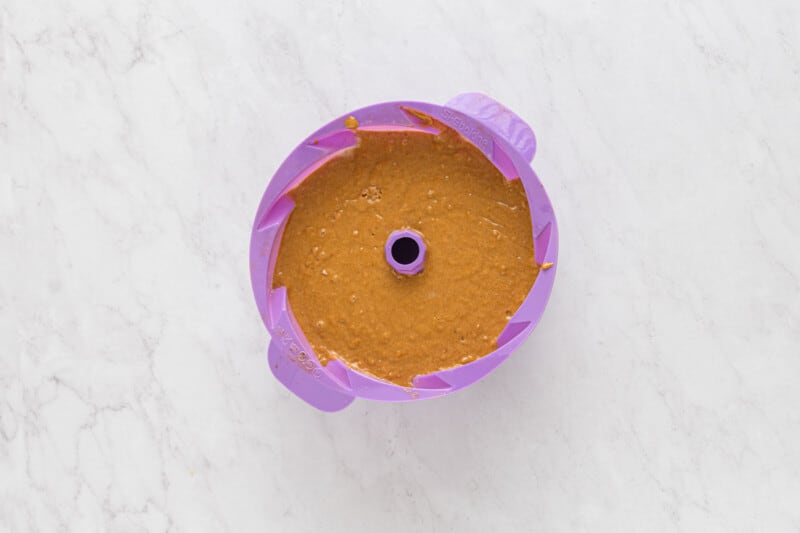 gingerbread bundt cake batter in a purple silicone bundt mould.