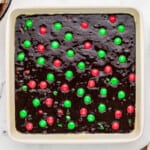 brownies with christmas M&Ms in a white baking dish before baking