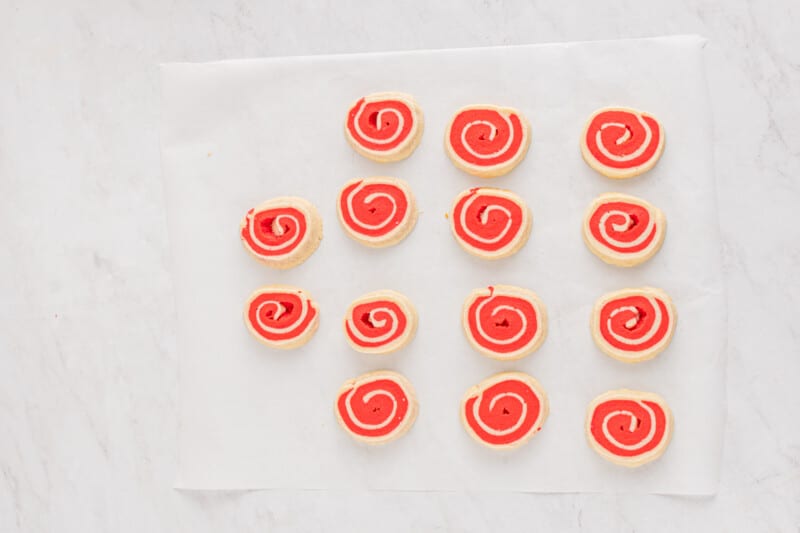 white and red pinwheel cookies on parchment paper before baking