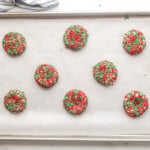 sugar cookies with red and green sprinkles on a baking sheet before baking