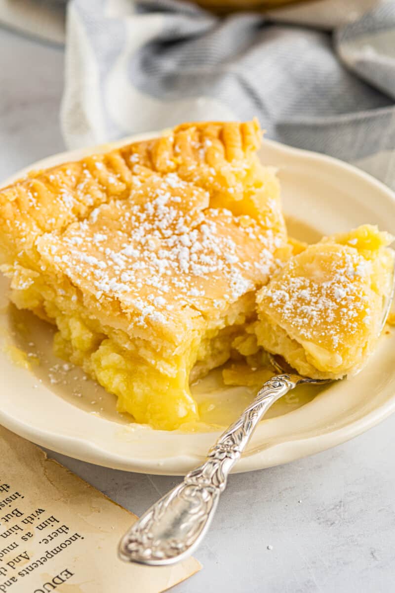 slice of buttermilk chess pie on a plate with a fork with a bite cut
