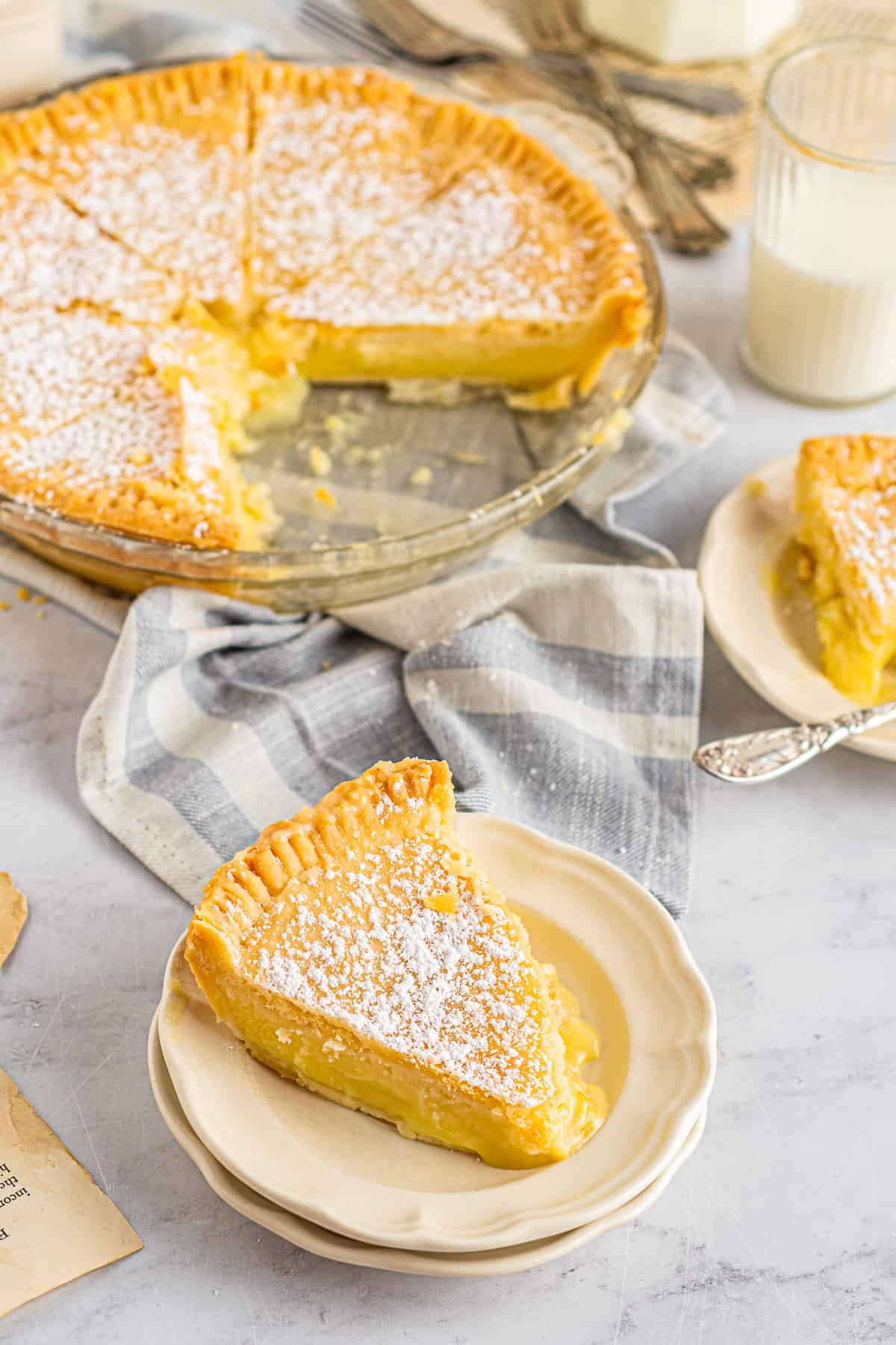 buttermilk chess pie in a glass pie dish and a slice of buttermilk chess pie on a plate