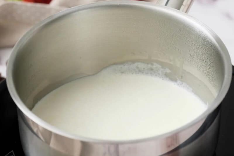 heating heavy cream in a saucepan.