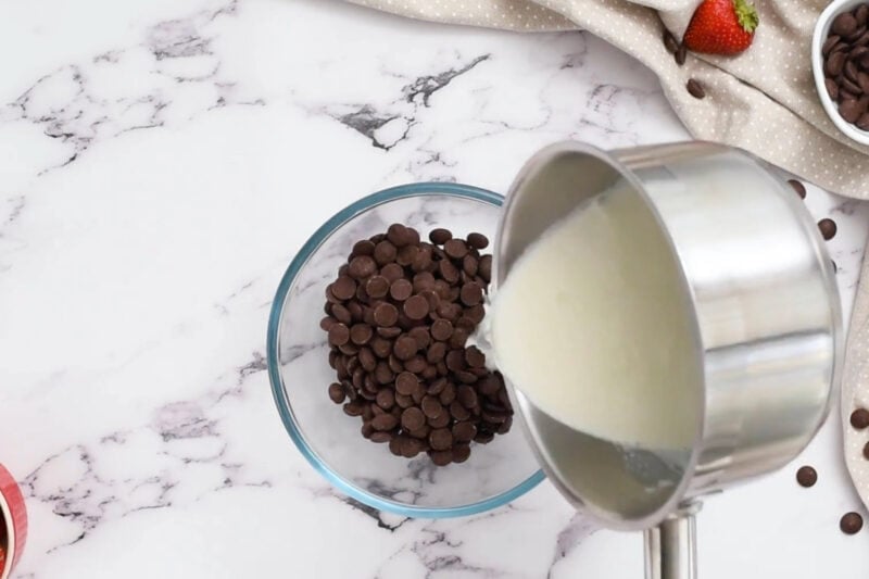 pouring heavy cream over chocolate chips.
