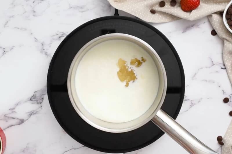 adding bloomed gelatin to heavy cream in a saucepan.