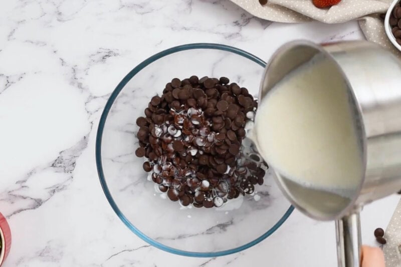 pouring gelatin-infused heavy cream over chocolate chips.