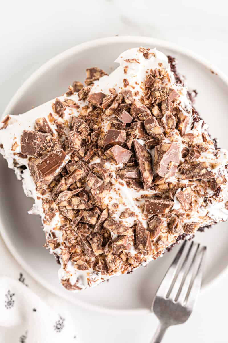 overhead image of a slice of better than sex chocolate cake on a white plate with a fork