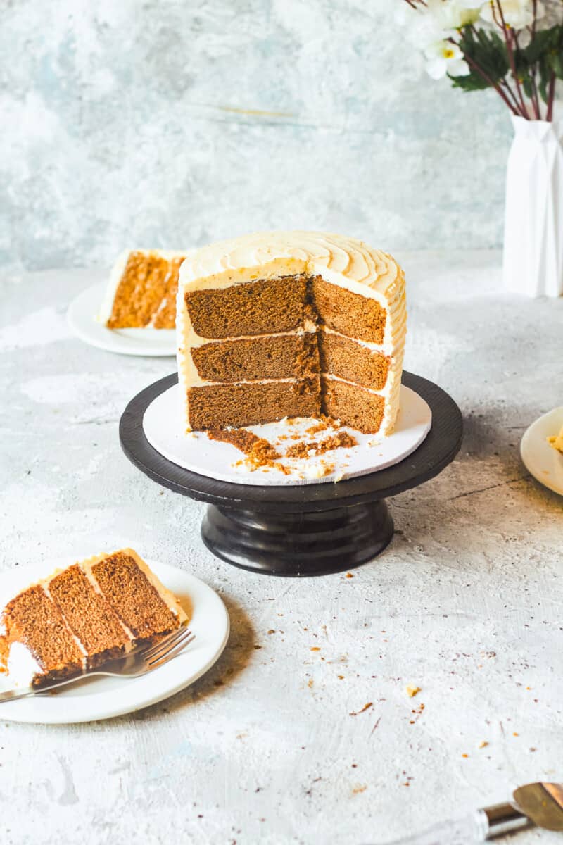 brown butter spice cake on a cake stand with slices removed showing the inside