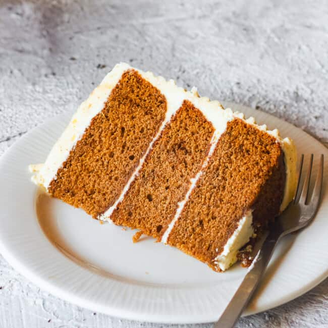 slice of brown butter spice cake on a white plate with a fork