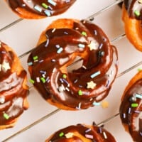 overhead image of chocolate glazed crullers on a cooling rack