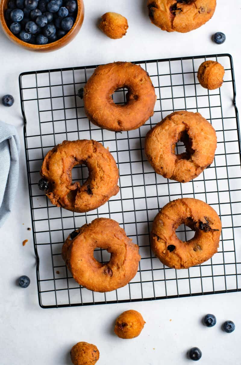 blueberry donuts on a cooling rack without glaze