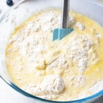 wet and dry ingredients in a glass bowl with a spatula