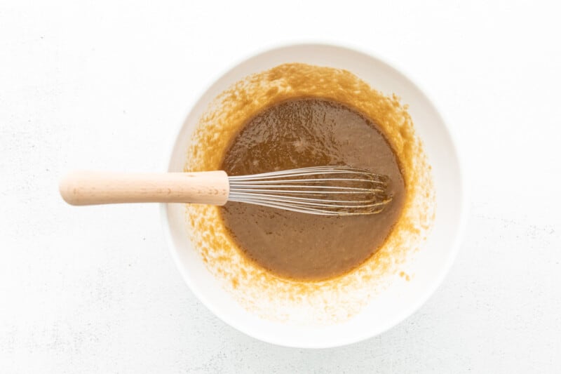 melted butter and brown sugar in a white bowl with a whisk