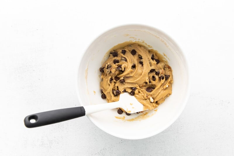 dark chocolate pretzel cookie dough in a white bowl with a spatula