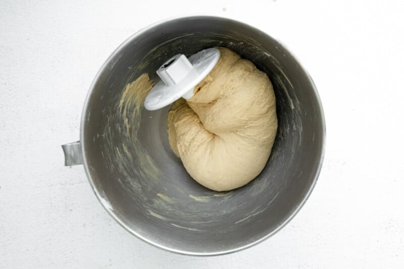 coffee donut dough in a metal mixing bowl with the dough hook attachment