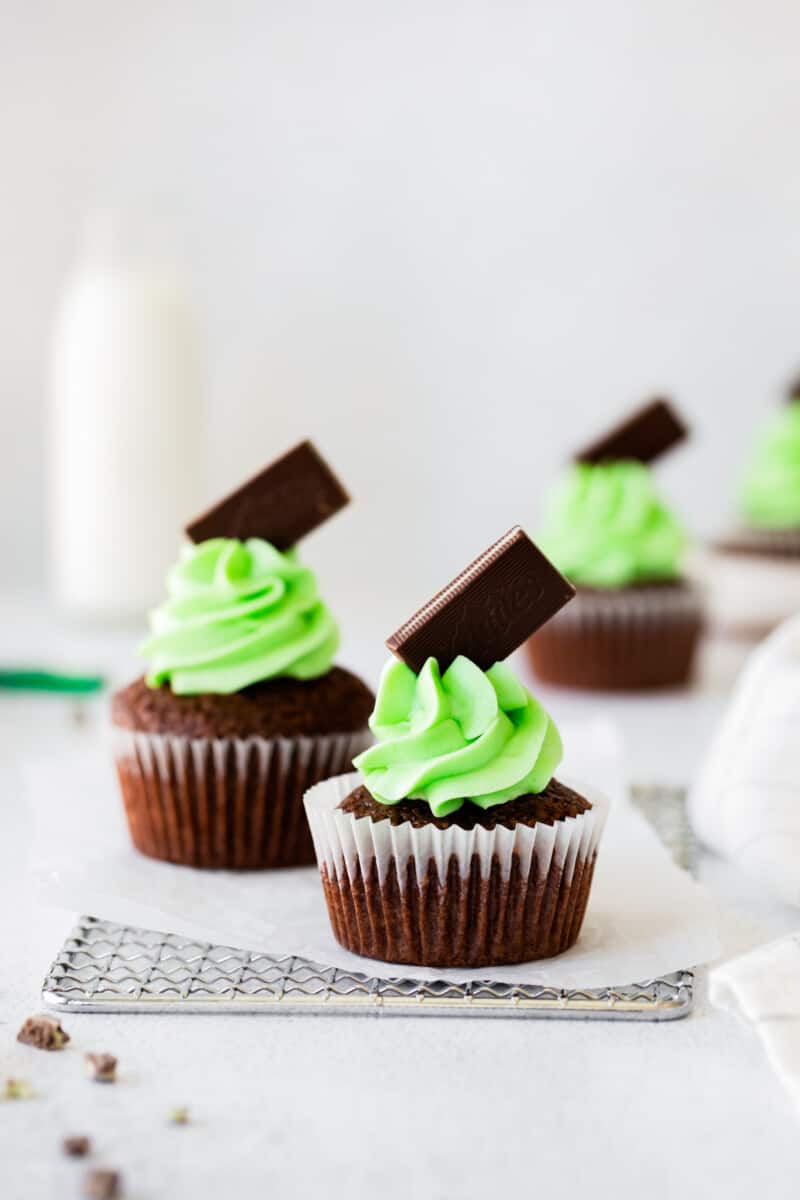 andes mint cupcakes topped with green mint buttercream frosting and andes chocolates