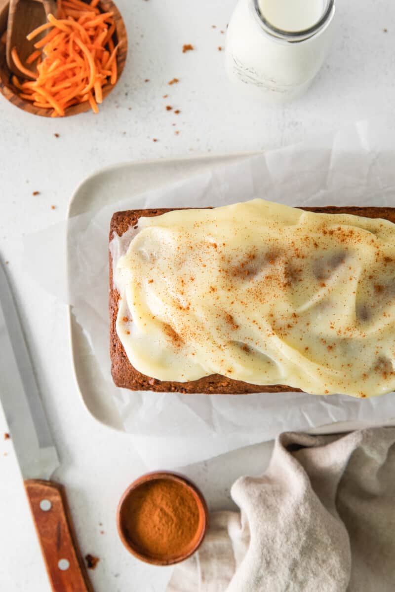 overhead image of carrot bread on a white serving platter topped with cream cheese glaze