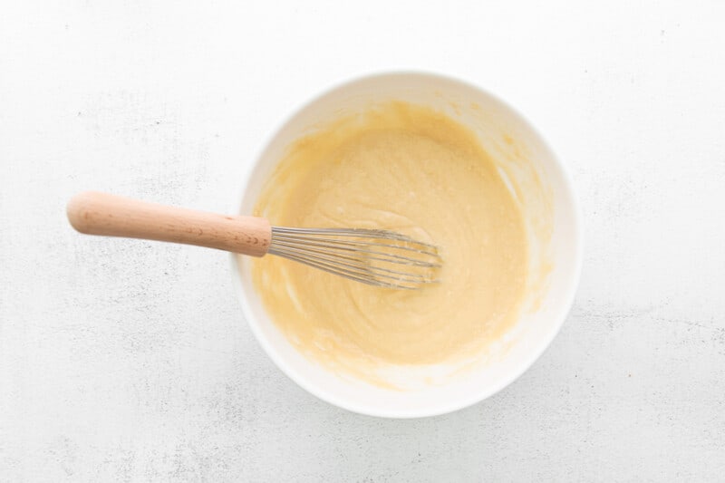 cupcake batter in a white bowl with a whisk