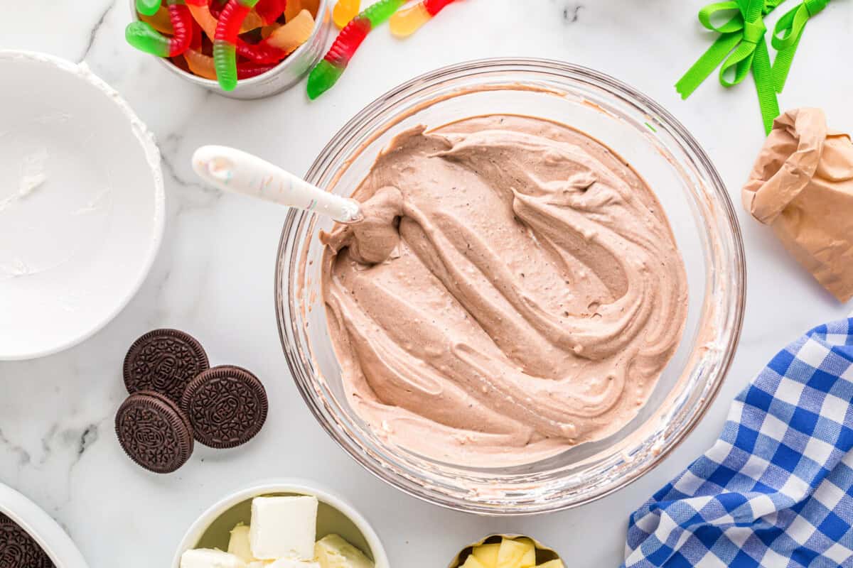 chocolate pudding cream cheese mixture in a glass bowl with a spatula