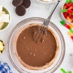chocolate pudding in a glass bowl with a whisk