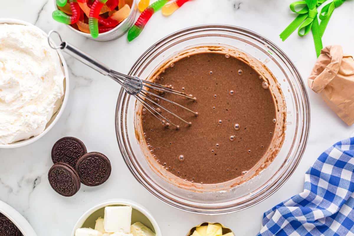 chocolate pudding in a glass bowl with a whisk