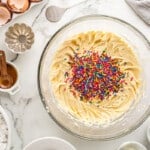 sprinkles added to pound cake batter in a glass bowl
